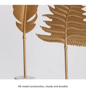 Detailed macro view of golden metal leaf ornament with brushed texture on marble base
