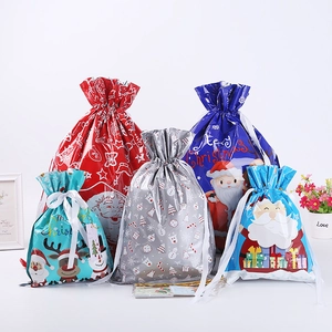 Festive Christmas drawstring gift bags with various colors and Santa motifs on white background