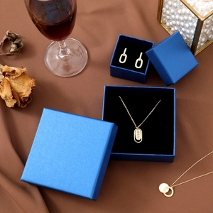 Elegant gold jewelry set with necklaces and earrings in a premium blue matte gift box