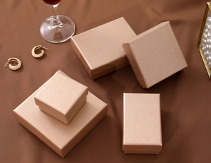 Champagne gold jewelry gift boxes in various sizes on brown satin with luxury decor