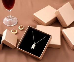 Champagne gold jewelry gift box with necklace and earrings in a premium lifestyle setting