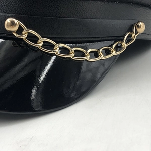 Black PU leather baker boy hat featuring a shiny visor and a gold metal chain accent