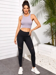 Détail du haut court côtelé violet clair et leggings en maille noire pour yoga fitness