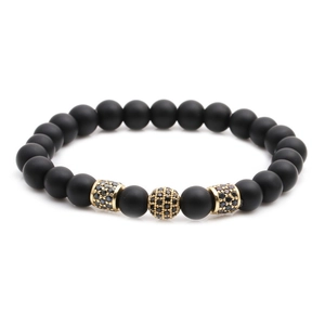 Matte black stone beaded bracelet set with gold crown accents and cubic zirconia