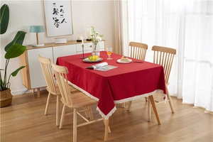 Close-up of red washed cotton tablecloth featuring delicate white fringe tassel edges