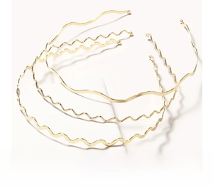Detailed view of three golden metal wavy headbands with protective rounded tips