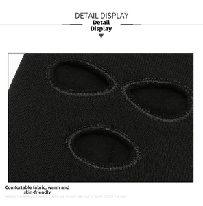 Close-up of black knitted balaclava showing reinforced stitching on the three-hole design