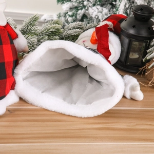 Christmas snowman gift bag with red black plaid and white faux fur trim on a festive tree