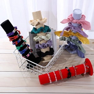 Velvet display pillars for jewelry and headbands with a metal storage basket organizer