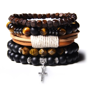 Macro detail of layered beaded bracelets featuring natural tiger eye stone and metal cross