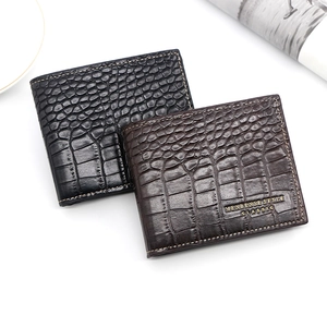 Close-up of men's bifold wallets in black and brown with glossy crocodile embossed texture