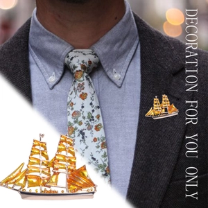 Artistic golden sailboat brooch with amber enamel and rhinestones shown on model