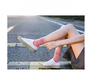Close-up of pink vertical striped cotton socks with thick rubber sole canvas shoes