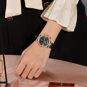 Detail of elegant ladies watch with green dial and gold rhinestone bezel on a model
