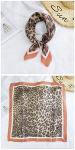 Close-up of leopard print cotton linen square scarf with orange borders and tied detail