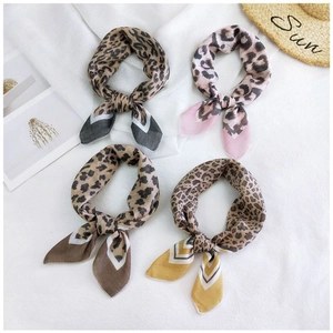 Flat lay of leopard print silk scarves in brown, pink, coffee and yellow colors