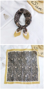 Detail view of leopard print cotton linen square scarf with yellow border and elegant knot
