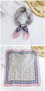 Detail view of leopard print cotton-linen scarf with pink border and brown patterns