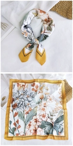 Detail of floral butterfly print silk square scarf with yellow border on linen backdrop