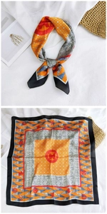 Detail of silk square scarf featuring orange geometric patterns and heritage horse emblems