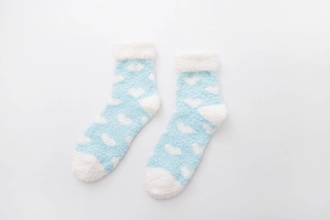 Detail of blue coral fleece socks with white heart patterns and soft rolled cuffs