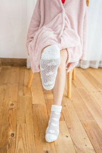 Close-up of soft coral fleece striped socks worn in a cozy home setting for comfort