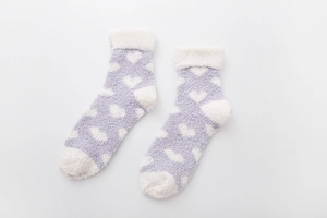 Close-up of soft coral fleece heart pattern socks with cozy white plush lining detail