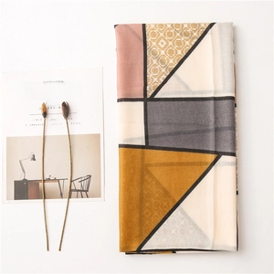 Flat lay of geometric pattern cotton linen scarf with soft pink and grey color blocks