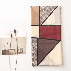 Flat lay of a geometric patterned cotton linen scarf with vintage burgundy and grey tones