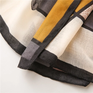 Detailed macro view of geometric mustard yellow and grey cotton linen scarf fabric texture