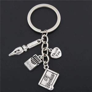 Detailed view of silver teacher keychain with Thank You heart and crayon charms