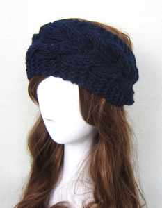 Close-up of dark blue knit headband on mannequin featuring thick cable knit texture