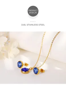 Detail of 316L stainless steel gold necklace and blue zircon earrings set on white leather