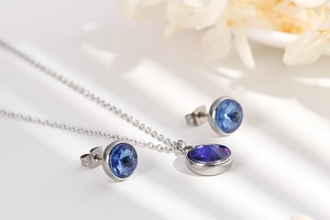 Detail view of silver titanium steel jewelry set with round blue faceted zircon stones