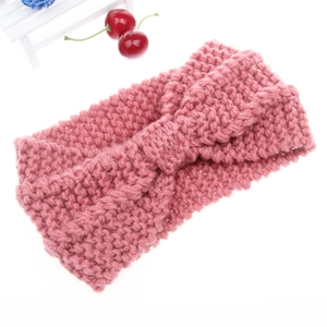 Detail of pink knitted headband showing chunky knit texture and stylish twist design