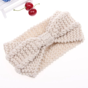 Detail of creamy beige chunky knit headband featuring a bohemian bow design for winter