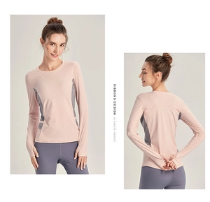 Détail du haut de sport rose à manches longues avec passe-pouces et panneaux gris
