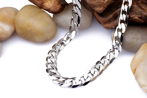 Detail of 7mm silver titanium steel cuban link chain on river stones and wood