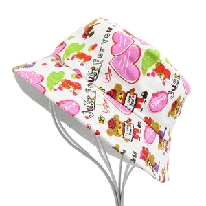 Detail view of a white canvas bucket hat featuring colorful cartoon doodles and lettering