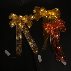 Detail of LED glowing Christmas ribbon bow with mesh stars and battery box