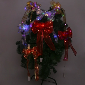 Close-up of LED glowing silver Christmas bows on tree with colorful festive lights