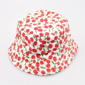 Detail shot of canvas sun hat featuring red cherry prints and white fabric texture