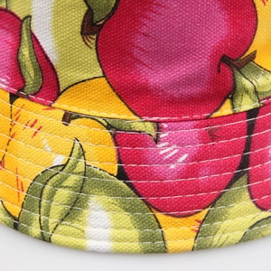 Macro view of canvas bucket hat featuring fruit prints and high-density stitching
