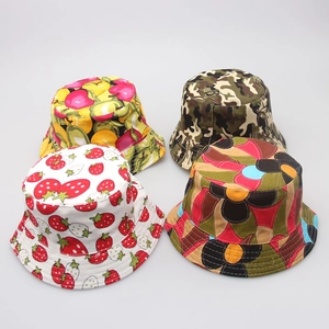Flat lay of colorful children's sun hats with strawberry, fruit, and camo prints