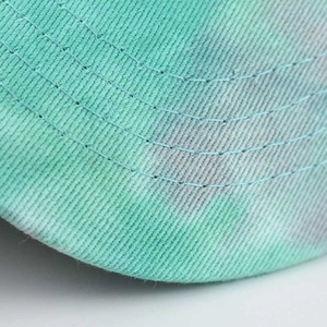 Macro detail of cotton tie-dye sun hat brim featuring neat stitching and vibrant blue-grey tones