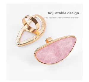 Draufsicht auf verstellbare Nagelkunst-Ringe mit rosa Marmor und Goldbeschichtung
