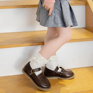 Girls white lace princess socks paired with brown leather Mary Jane shoes on wooden stairs