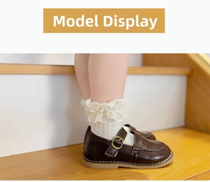 Detail of brown Mary Jane leather shoes for girls paired with white lace ruffle socks