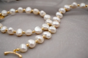 Macro shot of baroque freshwater pearl bracelet with 18K gold toggle clasp and beads
