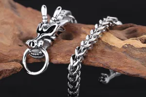 Détail du fermoir tête de dragon sculpté et de la chaîne tressée en acier inoxydable